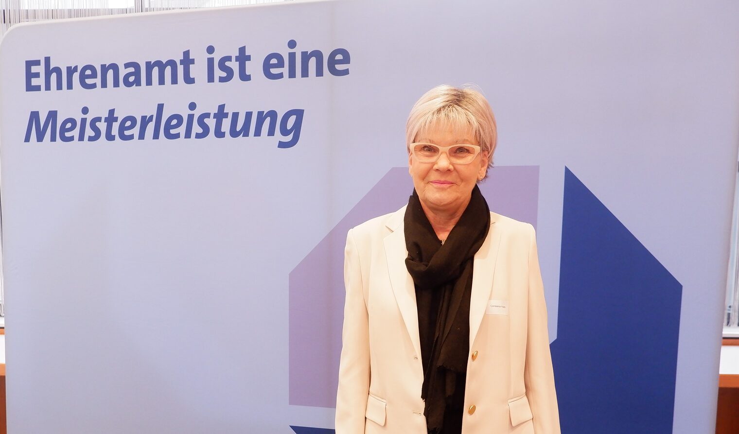 Constanze Huep steht vor einem Roll up Ehrenamt ist eine Meisterleistung.