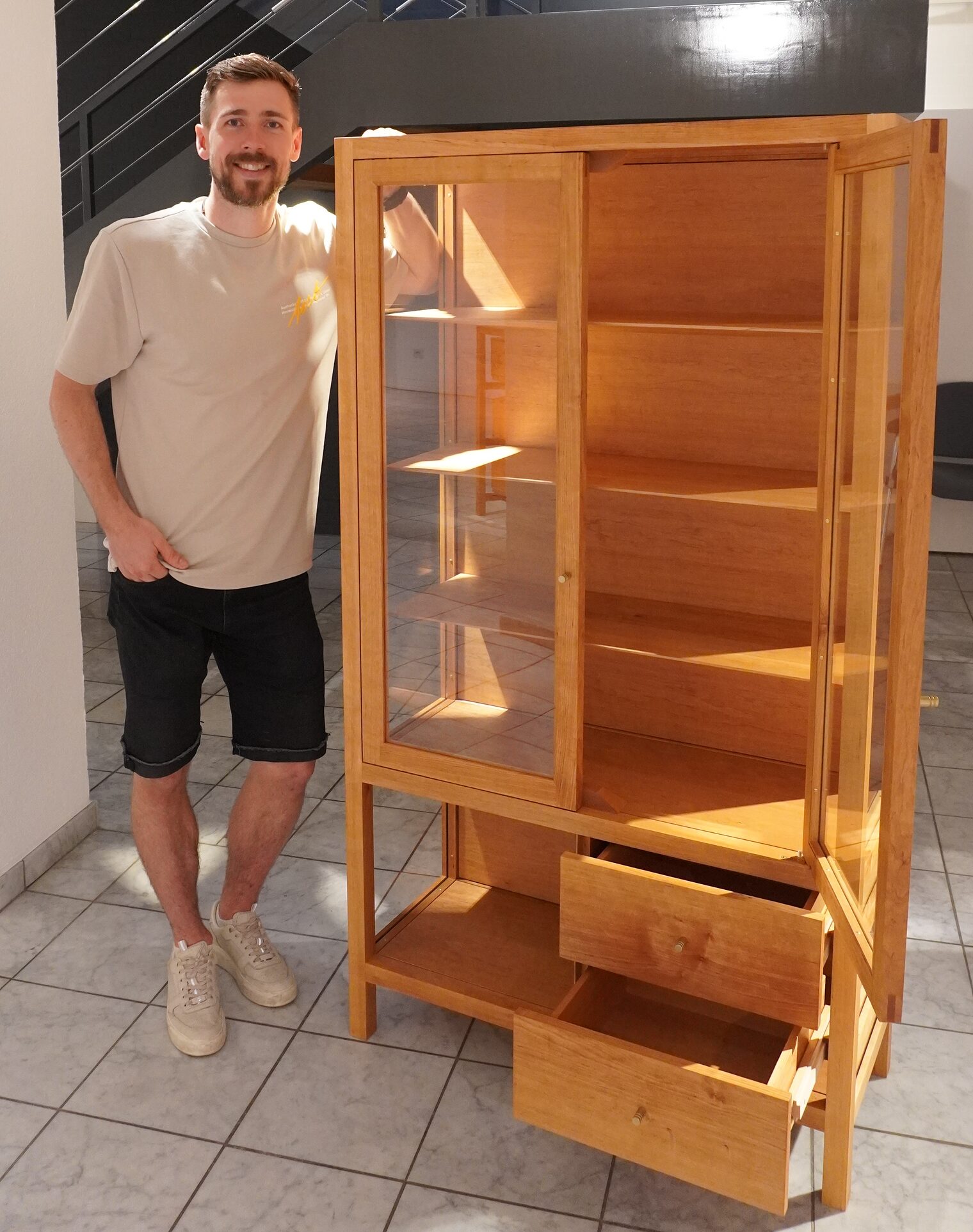 Tischlermeister Jannis Pläschke lehnt sich an sein Meisterstück.