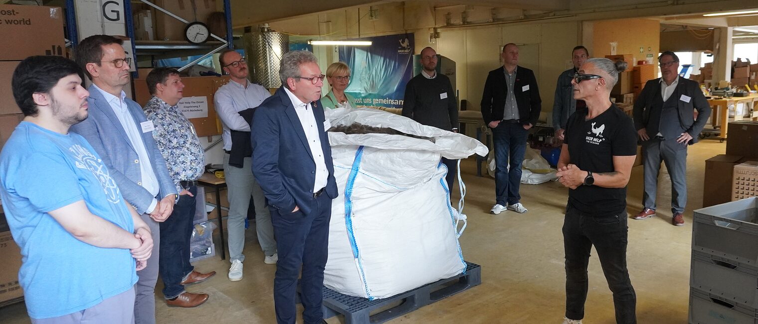 Emidio Gaudioso erläutert seine Idee in einer großen Halle vor einem Sack voller Haare.